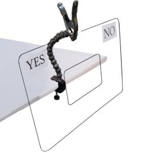 Black clip clamp attached to white table holding sign.